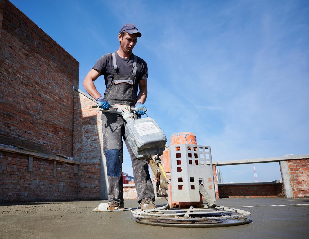 travailleur-utilisant-truelle-mecanique-chantier-construction - CAEN-AMENAGEMENTS-EXTERIEURS - Enrobe - Caen - 14